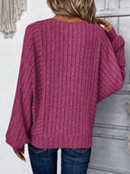 Back view of a woman wearing a magenta ribbed knit sweater with wide sleeves.