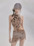 Model posing in a sheer mesh butterfly print two-piece outfit.