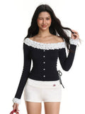 Woman modeling a black long-sleeved top with white ruffled detailing on the neckline and cuffs, featuring a button-down front and side ties.