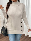 Woman showcasing a cream ribbed knit turtleneck tunic sweater with button accents and a black handbag.
