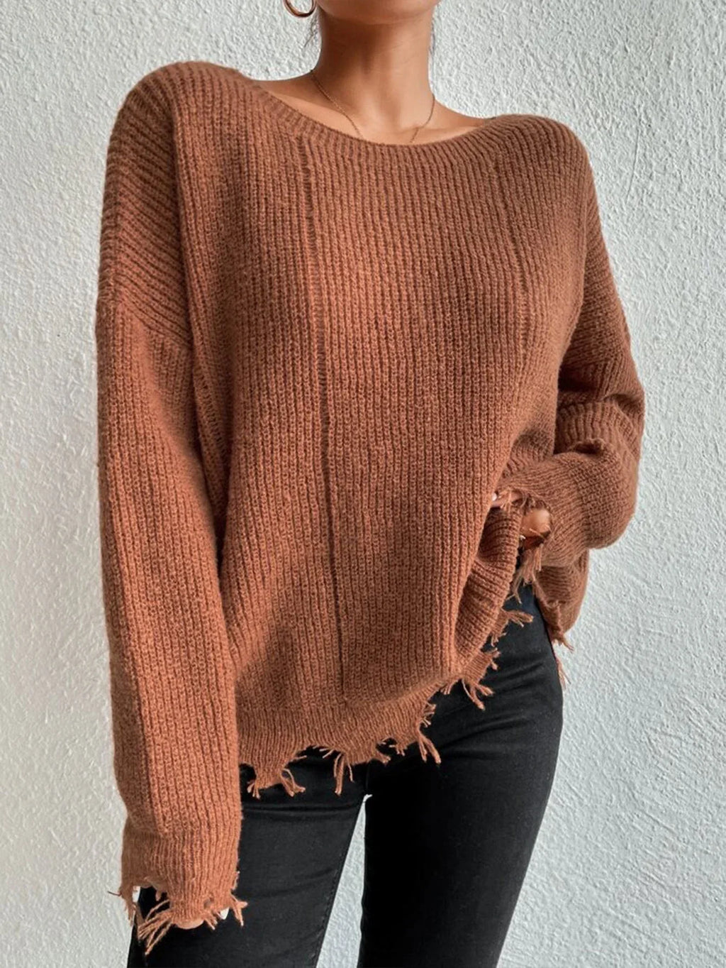 Woman wearing a rust-colored oversized distressed knit sweater