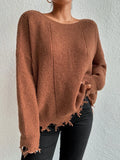 Woman wearing a rust-colored oversized distressed knit sweater