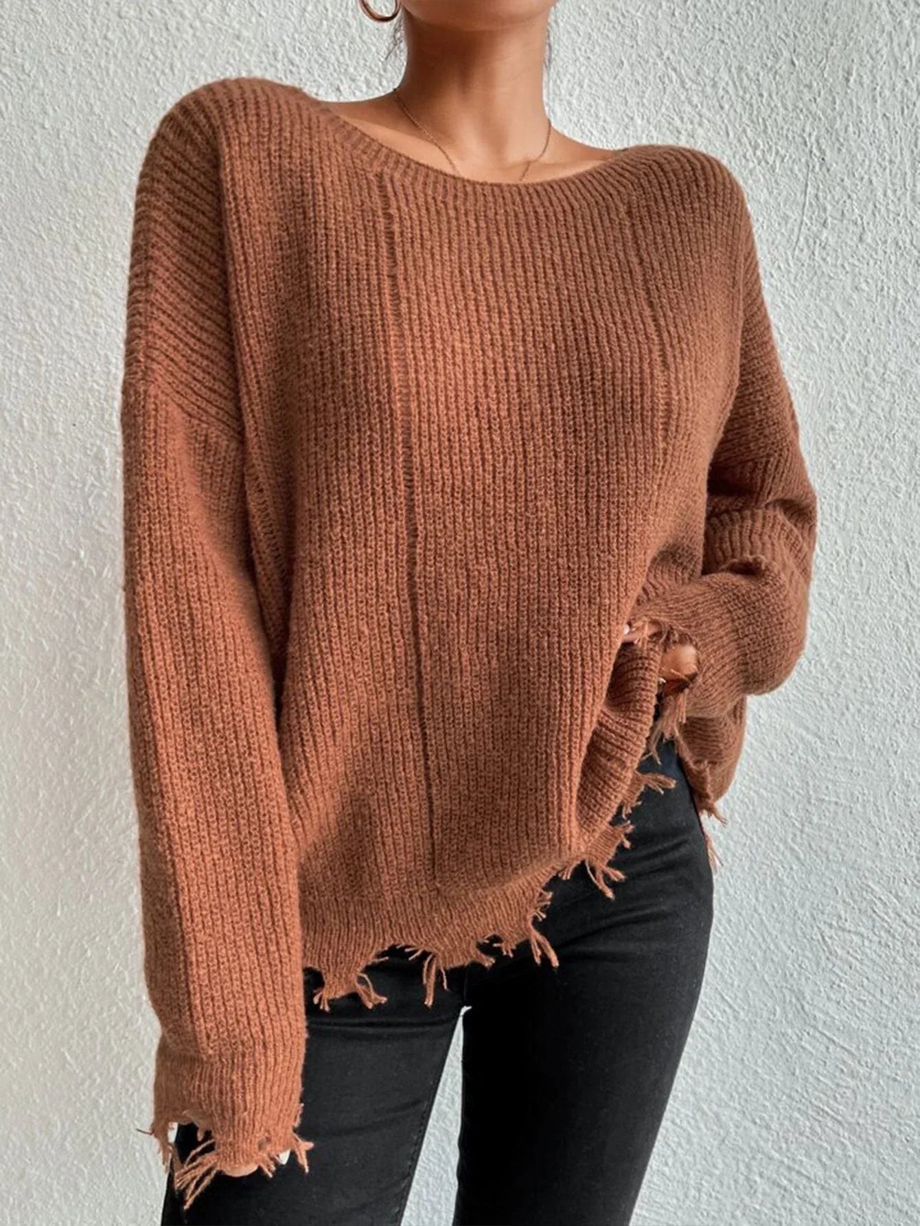 Woman wearing a rust-colored oversized distressed knit sweater