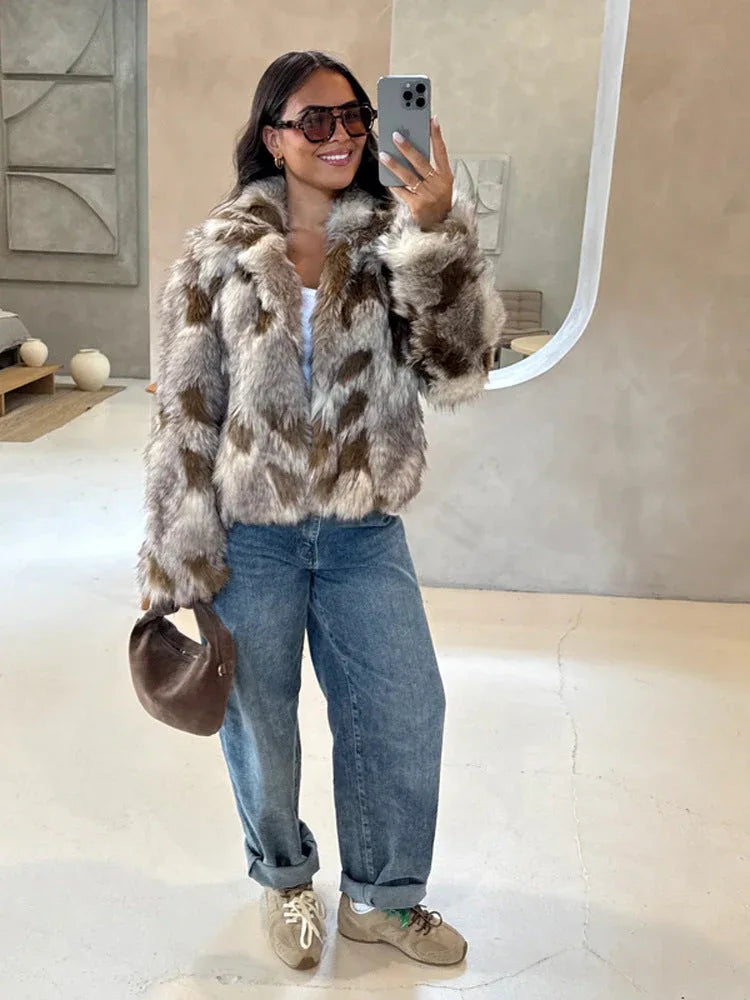 Woman in a brown and white faux fur jacket and blue jeans