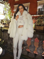 Woman wearing a white oversized faux fur coat with a large collar and full sleeves.