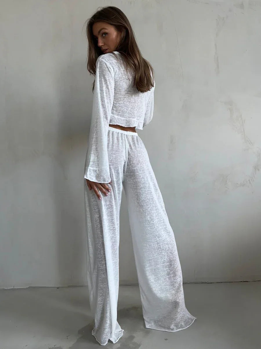 Back view of a woman in a white sheer knit set, featuring the flowy silhouette of the wide-leg pants and cropped top.