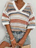 Woman wearing a white, tan, blue, and rust striped open knit V-neck cropped sweater with short sleeves.