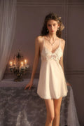 Front view of a woman in a white satin babydoll nightgown with delicate lace accents.