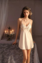 Front view of a woman in a white satin babydoll nightgown with delicate lace accents.