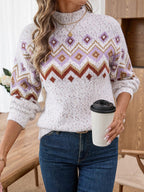 Close-up of a woman holding a coffee cup, wearing a white knit sweater with a geometric pattern.