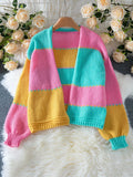 Multi-colored striped knit cardigan hanging on a wooden hanger