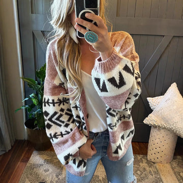 Woman wearing a pink, white, and black geometric pattern knit cardigan with balloon sleeves.
