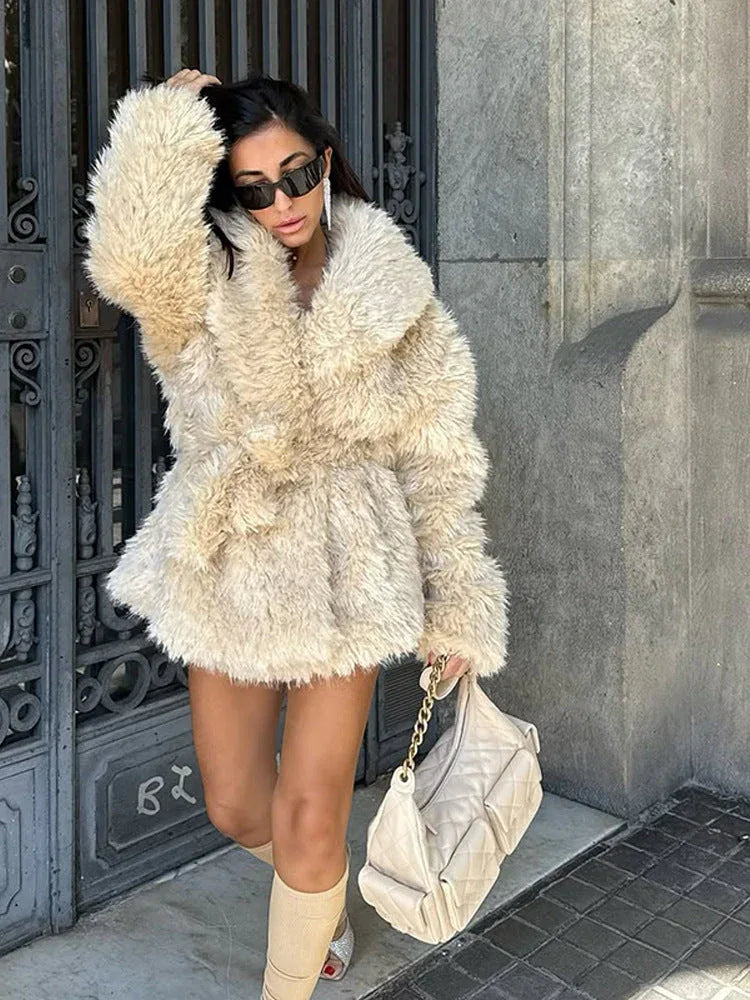 Close-up of a plush cream faux fur jacket with a large collar.