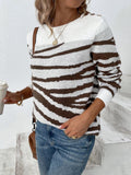 Woman holding a coffee cup while wearing a zebra print crew neck sweater