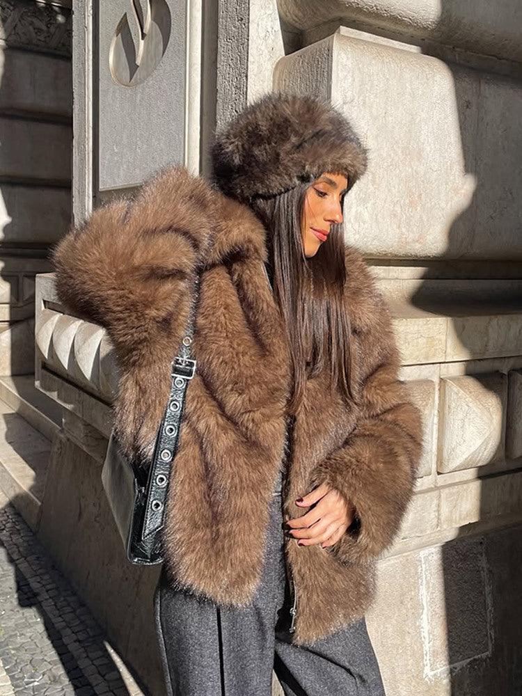 Fashionable woman in a luxurious brown faux fur coat, enjoying a beverage.