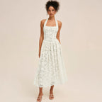Woman wearing a white lace halter midi dress, front view