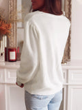 Back view of a woman in a white puffed-sleeve cardigan