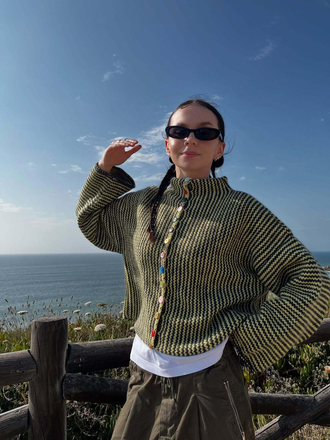 Woman wearing a yellow and black chevron knit button cardigan outdoors