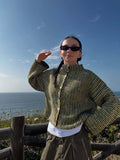 Back view of a woman in a textured knit cardigan with colorful buttons