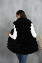 Back view of a woman in a black faux fur vest
