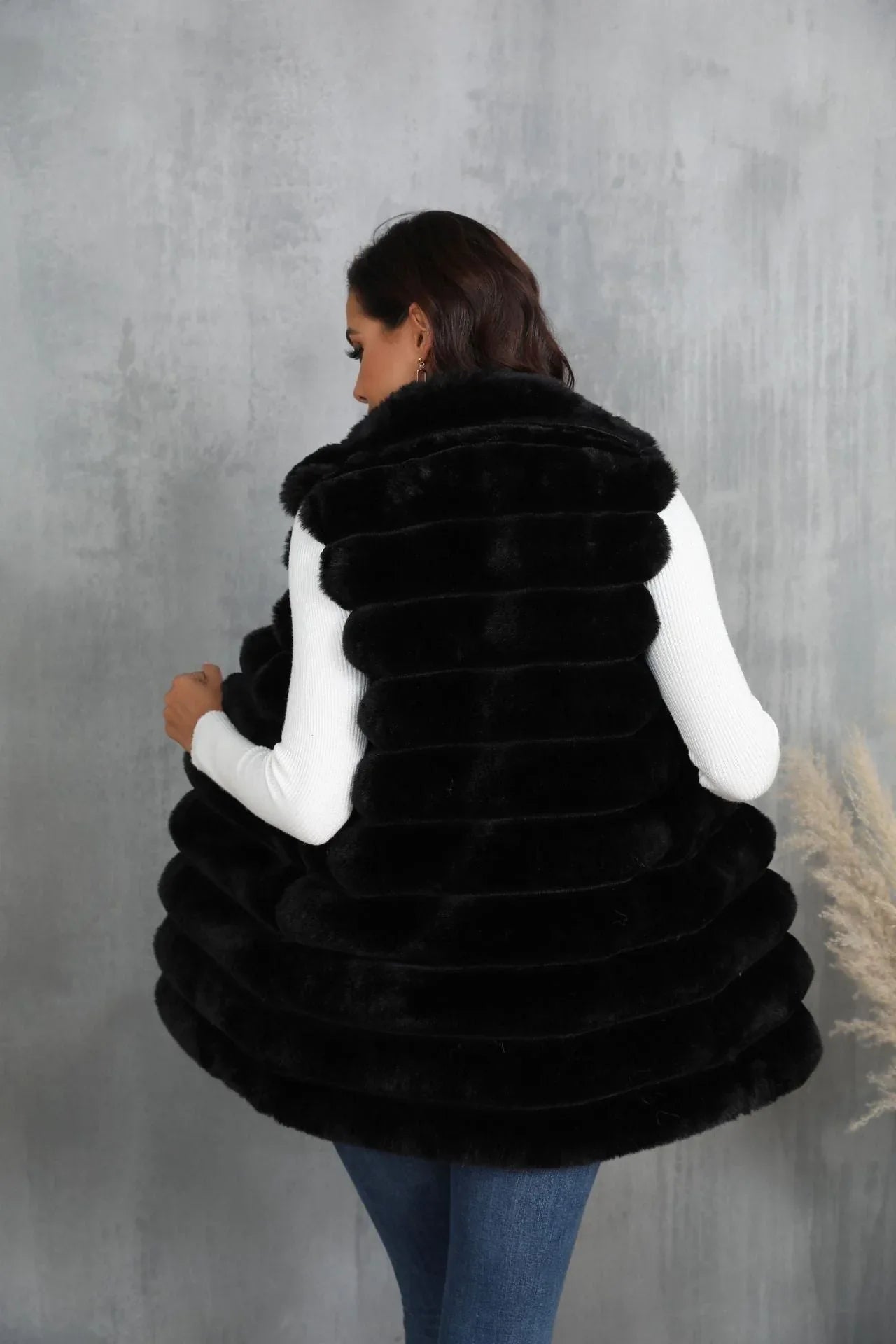 Back view of a woman in a black faux fur vest