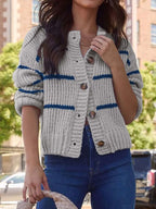 Front view of a woman in a gray and navy striped button-up knit cardigan.