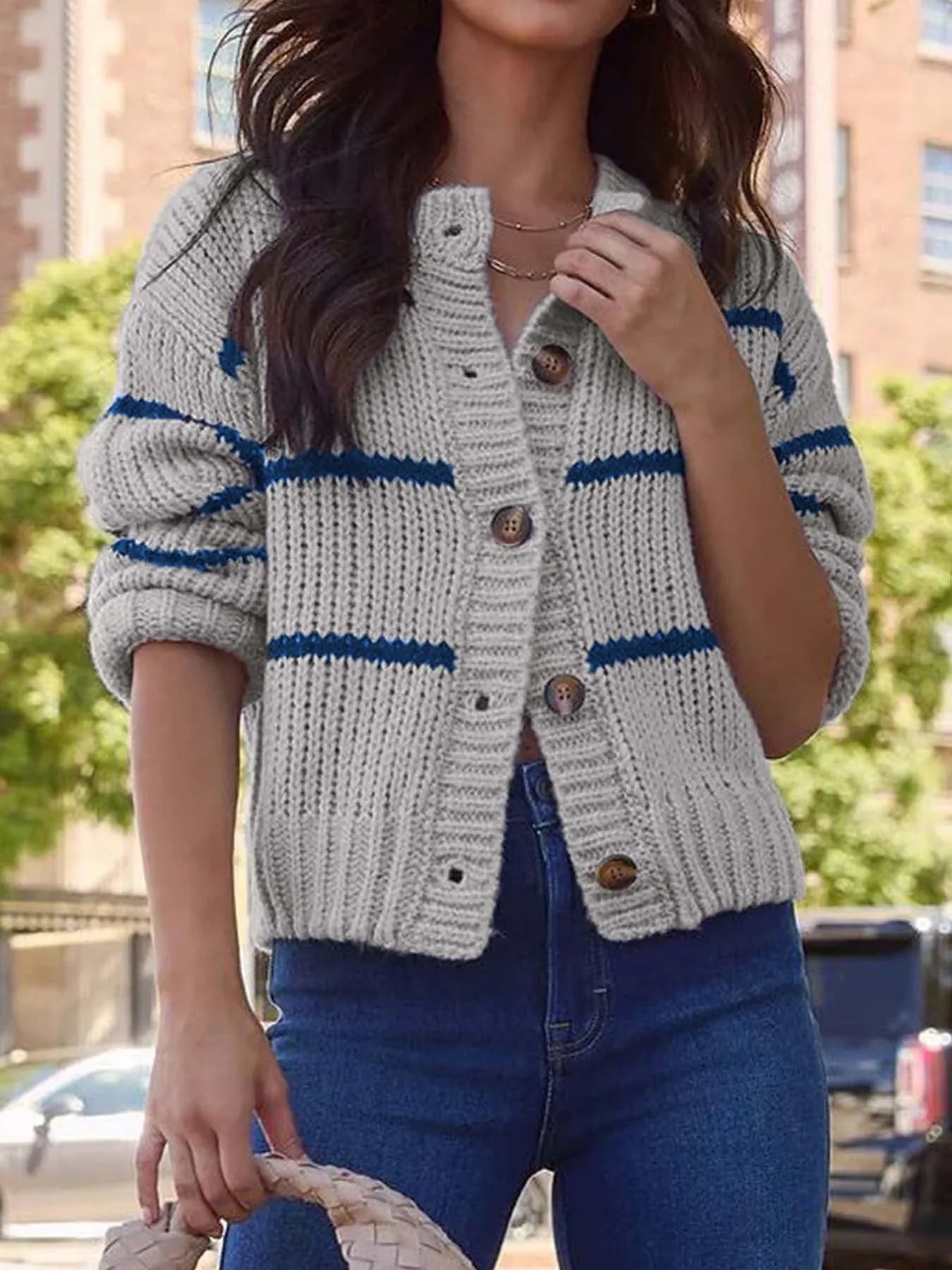 Front view of a woman in a gray and navy striped button-up knit cardigan.