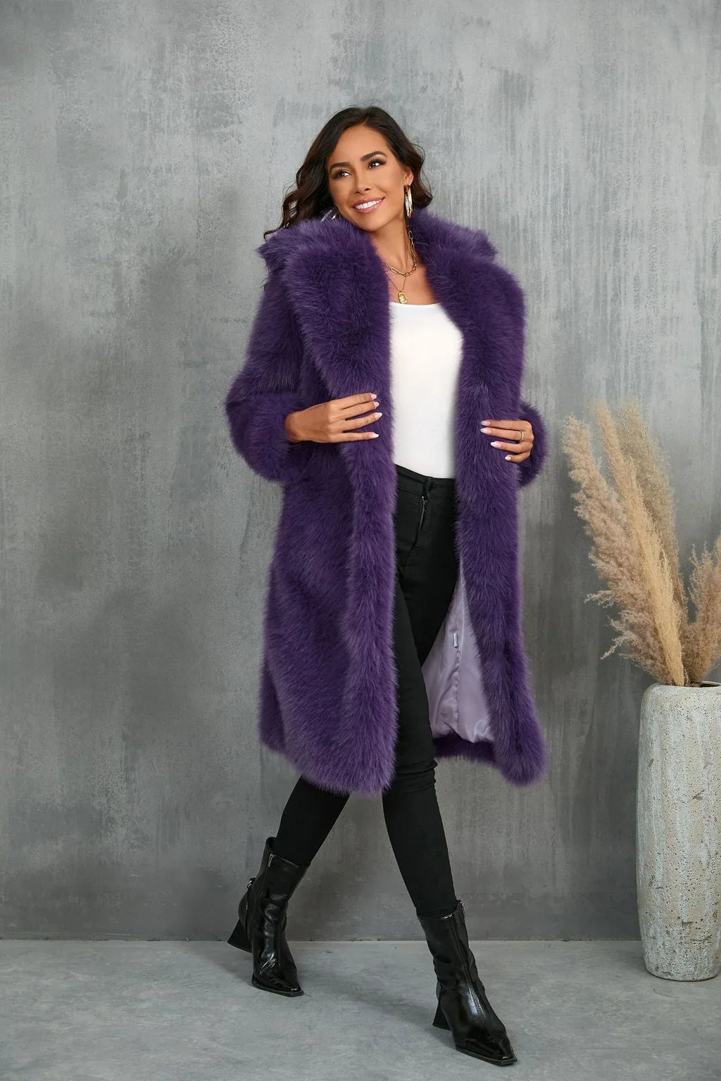 Woman posing in a purple faux fur coat, smiling.