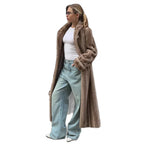 Full body shot of a woman wearing a long brown faux fur coat, white t-shirt, and light blue wide-leg jeans.