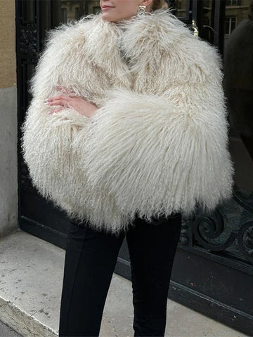 Woman wearing a cream shaggy faux fur cropped jacket