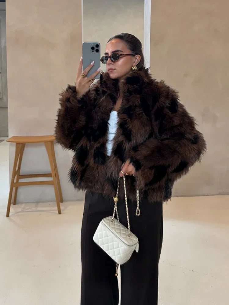 Woman in a dark brown and black faux fur jacket and dark pants