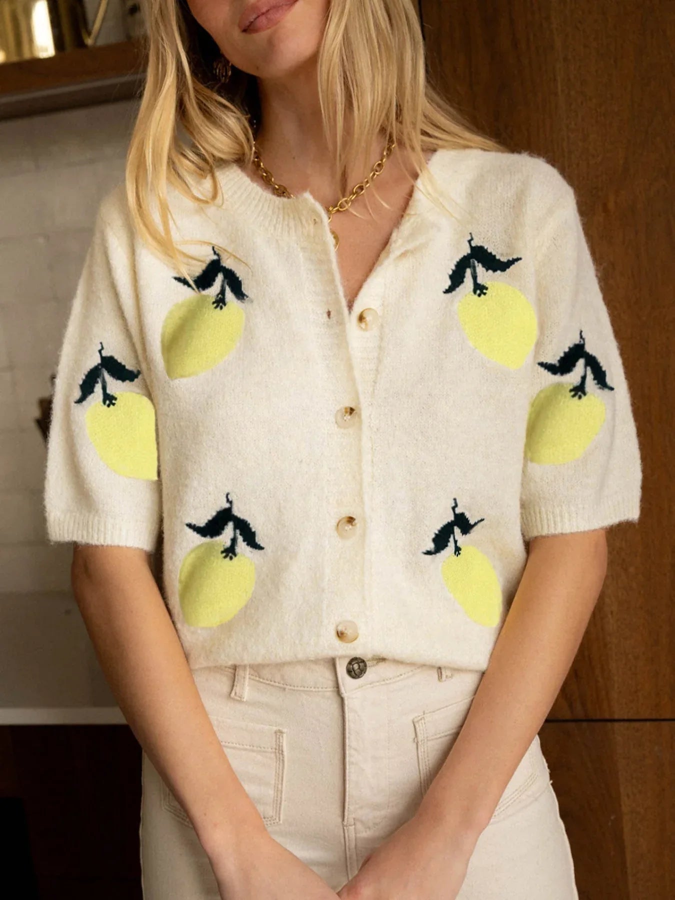 Front view of a cream knit cardigan with a lemon print