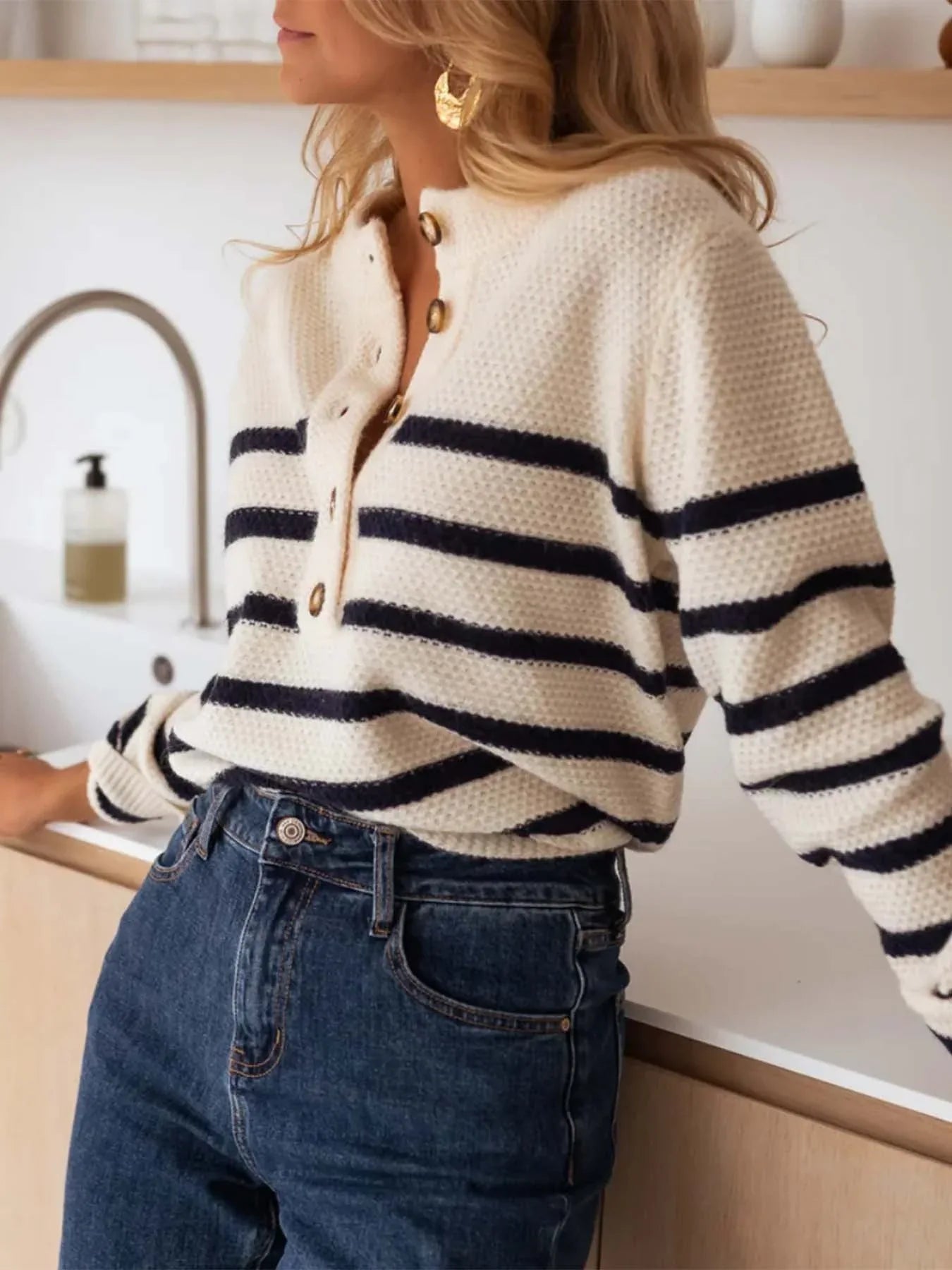 Woman wearing a striped knit sweater with a button-up placket. Main image