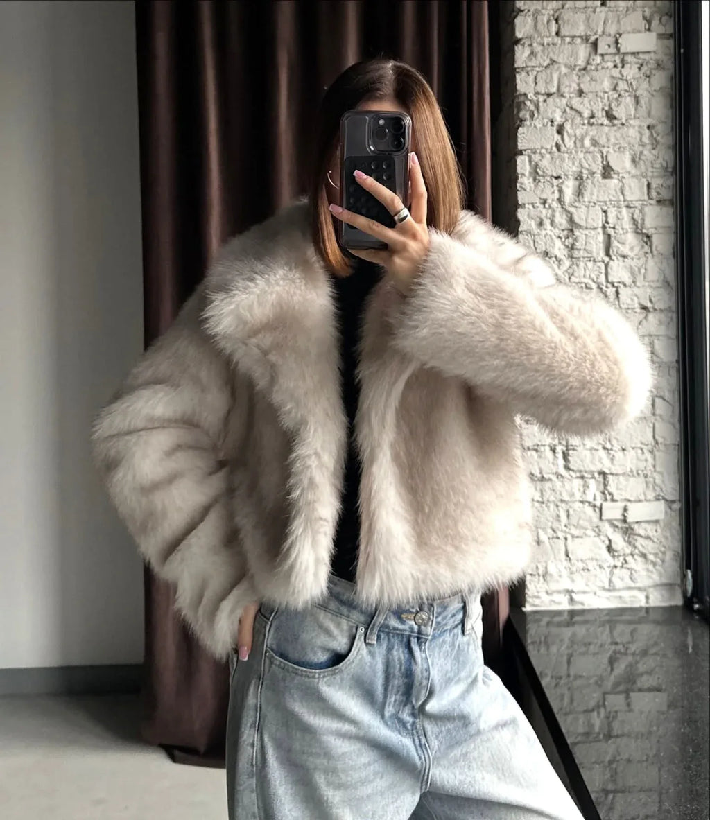 Close-up of the texture of a cream faux fur jacket.