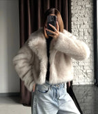 Close-up of the texture of a cream faux fur jacket.