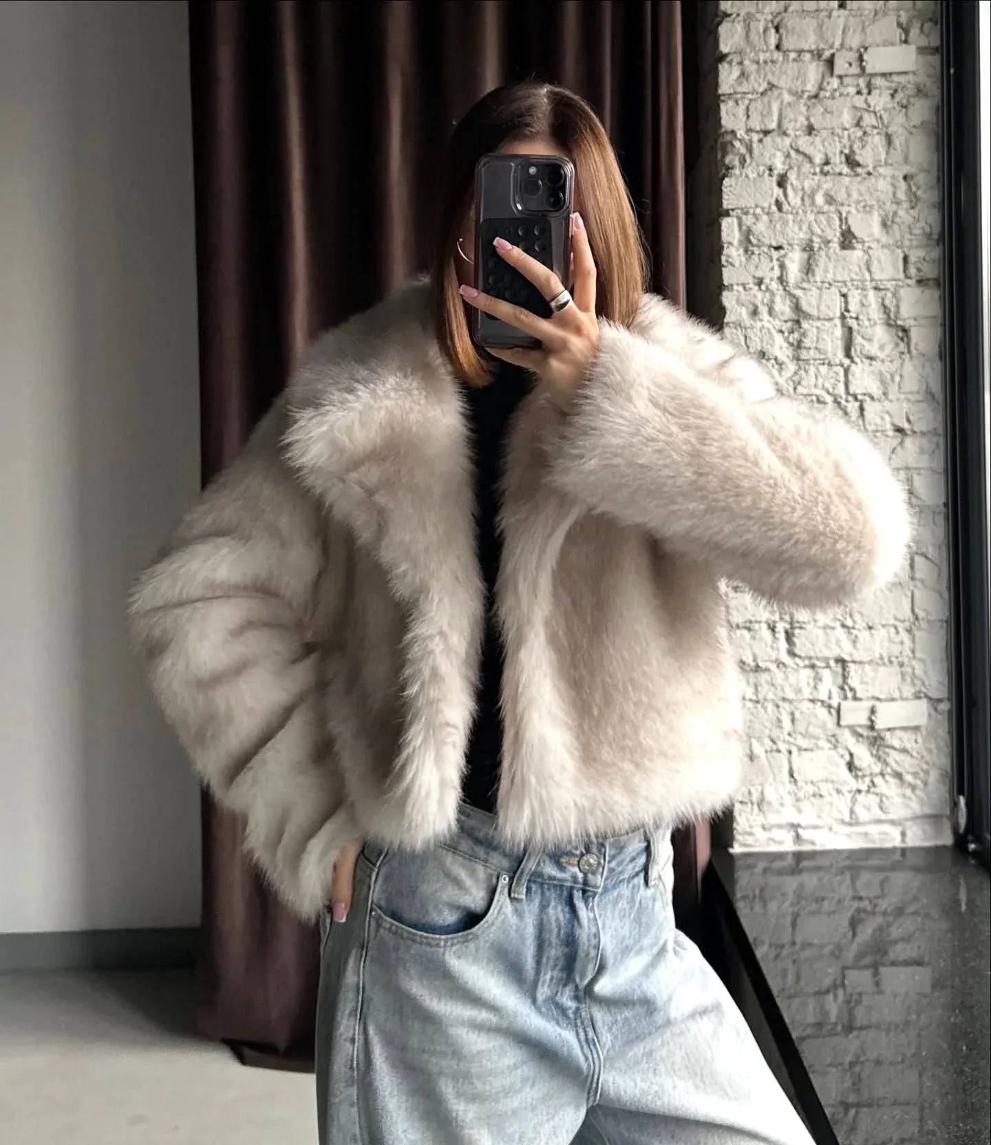 Close-up of the texture of a cream faux fur jacket.
