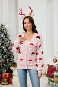 Woman smiling in a pink Santa Claus print cardigan with a V-neck and button-down closure.