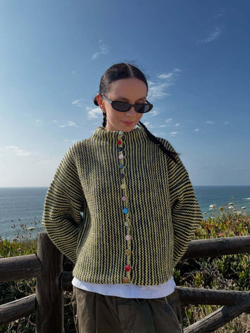 Woman wearing a yellow and black chevron knit button cardigan outdoors