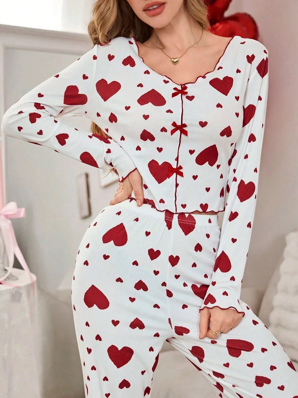 Close-up of a woman in white and red heart print pajamas, showing the top detail.