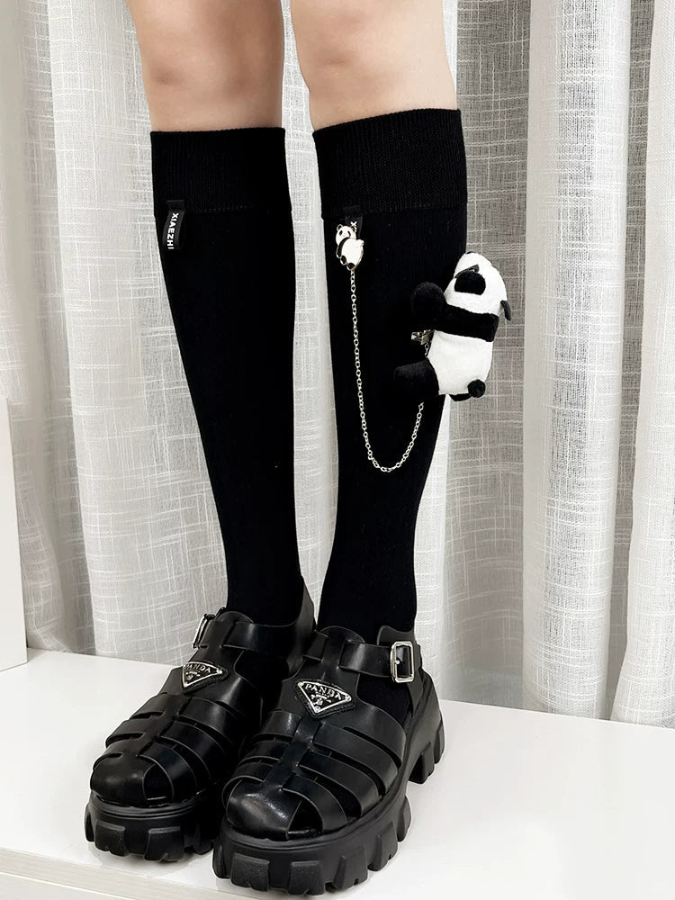 Black knee-high socks with a panda charm and chain detail.