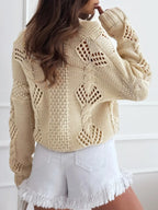 Back view of a beige cropped knit cardigan showing the open knit pattern.
