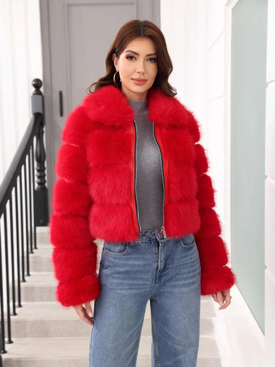 Woman wearing a red faux fur cropped jacket with a collared neckline and zipper closure, paired with a grey turtleneck and blue denim jeans. Main image