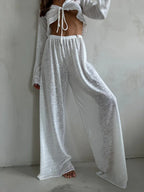 Close-up of the white sheer knit set, highlighting the V-neck tie-front top and drawstring waist pants.