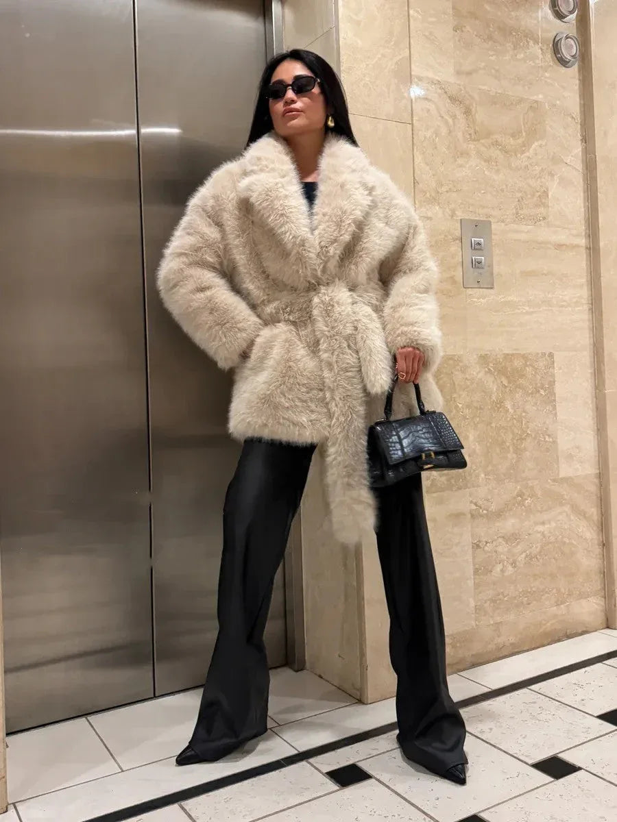 Cream faux fur coat with a belt and lapel collar on a woman.