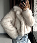 Detail shot of the faux fur texture and collar on a cream jacket.