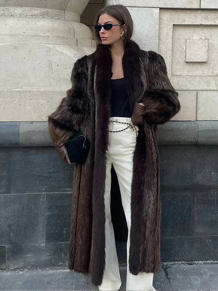 Woman wearing a long, dark brown faux fur coat with wide lapels.