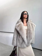 Full-body shot of a woman styled in a chic grey faux fur coat and a form-fitting knit dress.