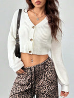 Close-up of a woman wearing a white cropped cardigan and leopard print pants