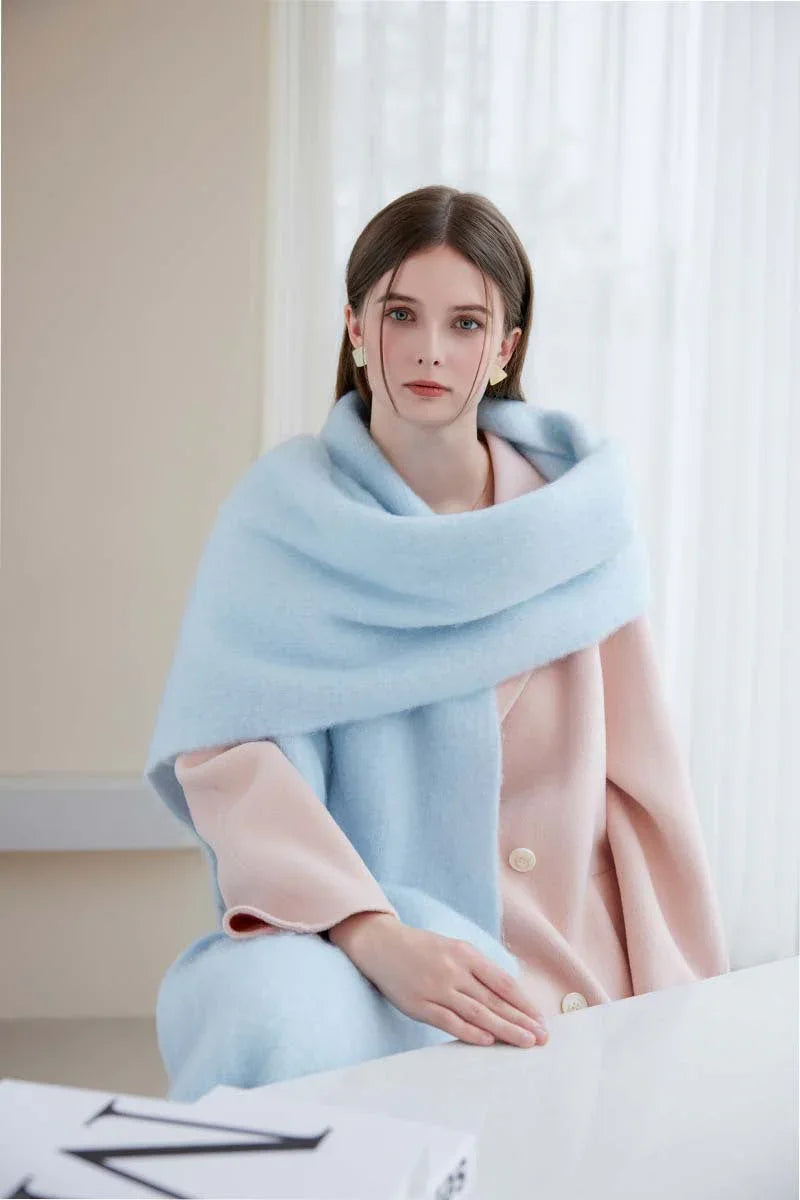 Woman in a pink coat with a light blue brushed mohair blend scarf around her neck.