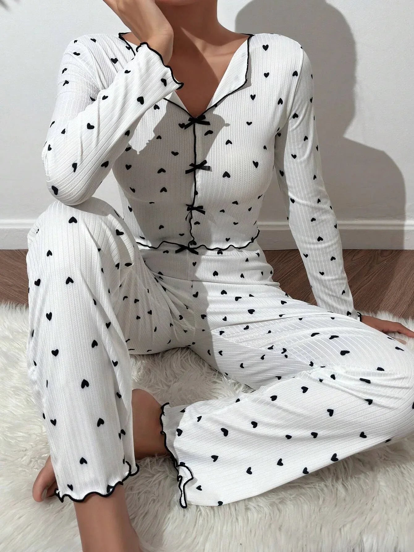 Back view of a woman in a pink heart print pajama set.